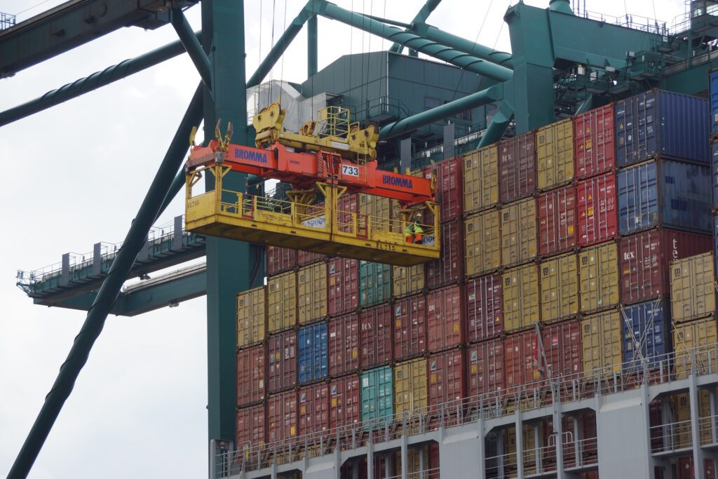 A crane removing a shipping container from a container ship docked at a port